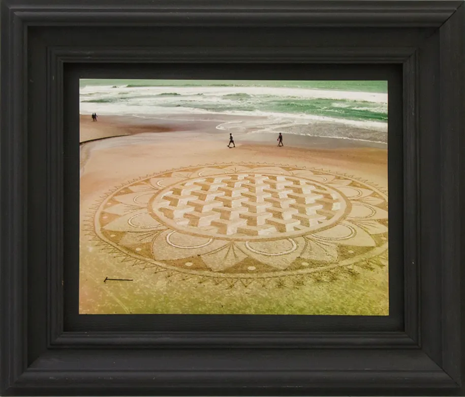 Fotografia emoldurada de mandala desenhada na areia