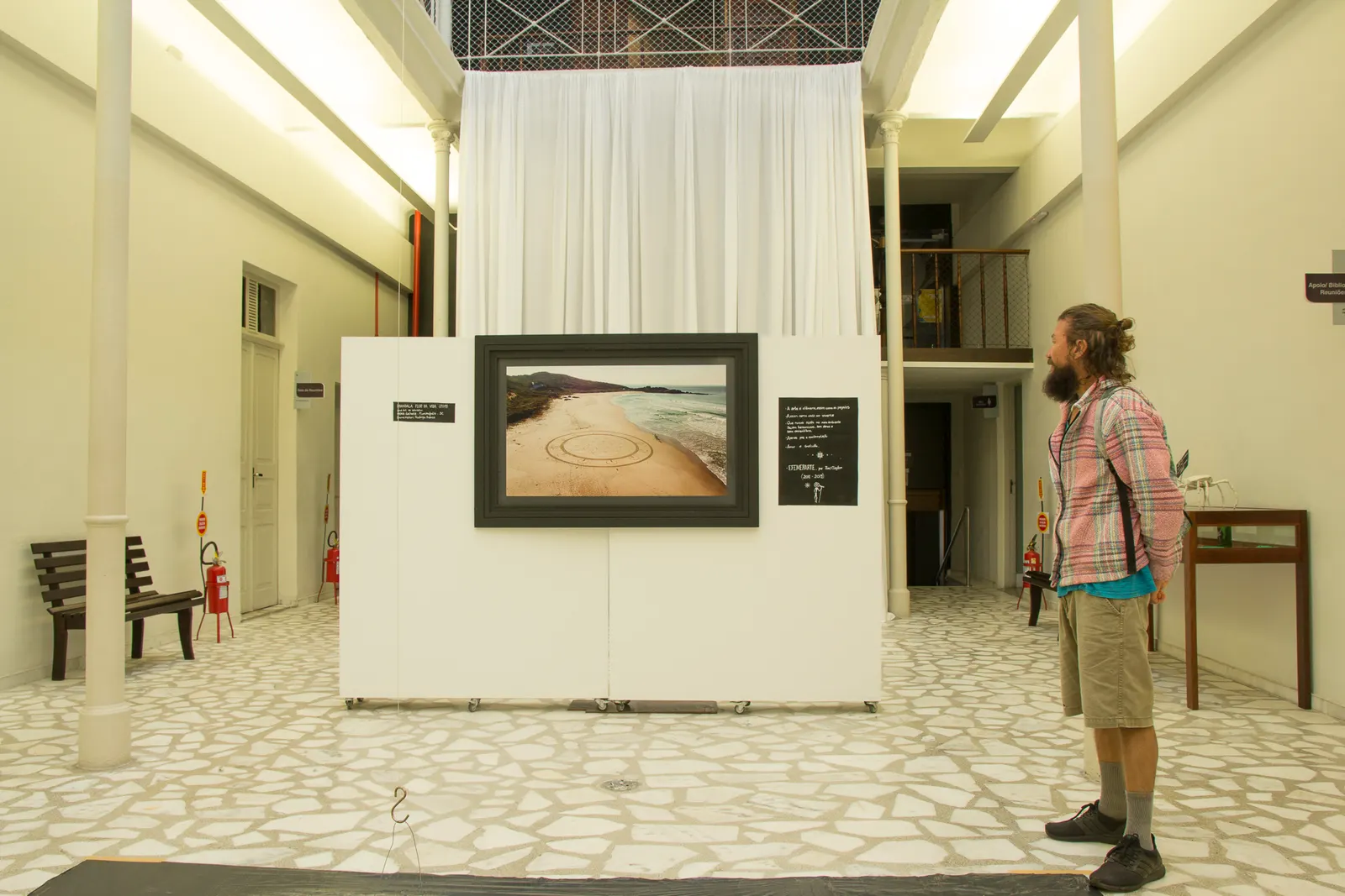 Sala da exposição EfemerArte, com fotografia de land art na parede