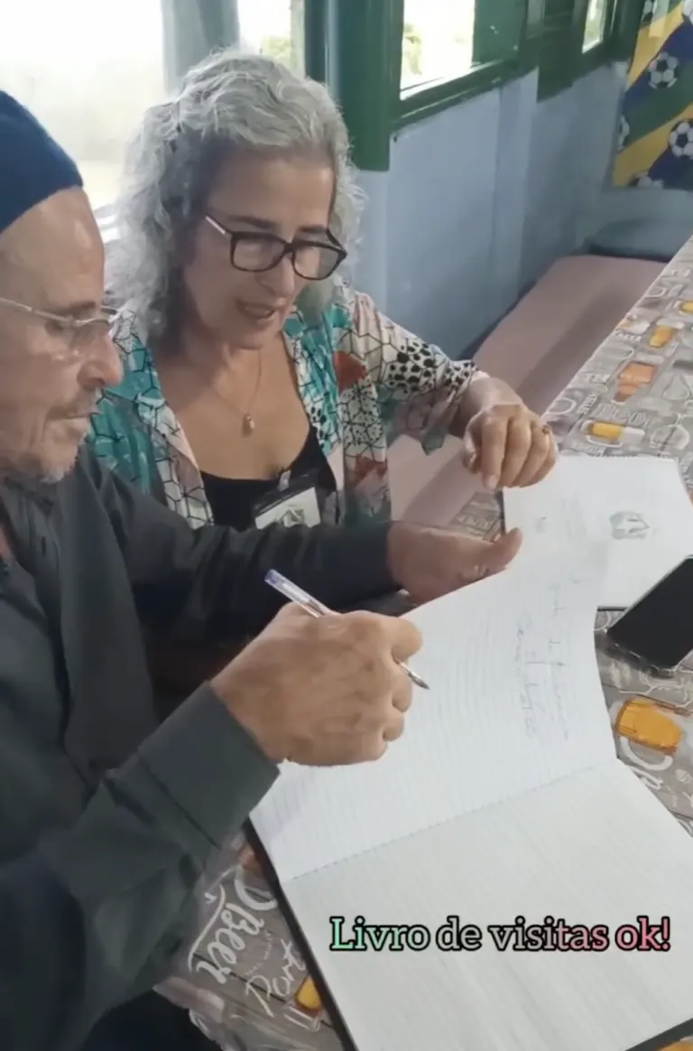 Paulinho e Sônia revisam o livro de visitas
