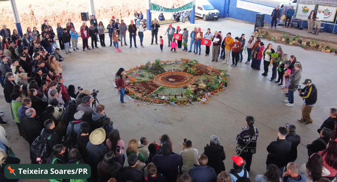Roda de pessoas em volta de uma mandala de sementes em Teixeira Soares, Paraná